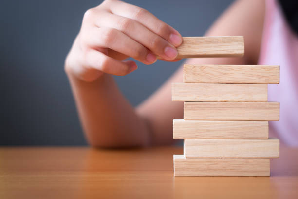 istock Girl's hand stacking wooden blocks. 1136304113