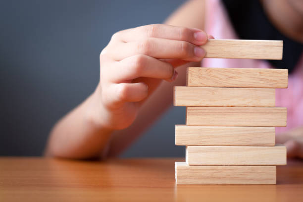 istock Girl's hand stacking wooden blocks. 1136304119
