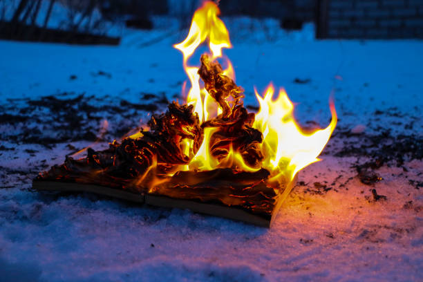 istock burning book in  snow. pages with the text in  open book burn with  bright flame. 1136306098