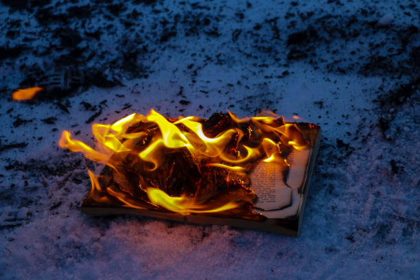 istock burning book in  snow. pages with the text in  open book burn with  bright flame. 1136306099