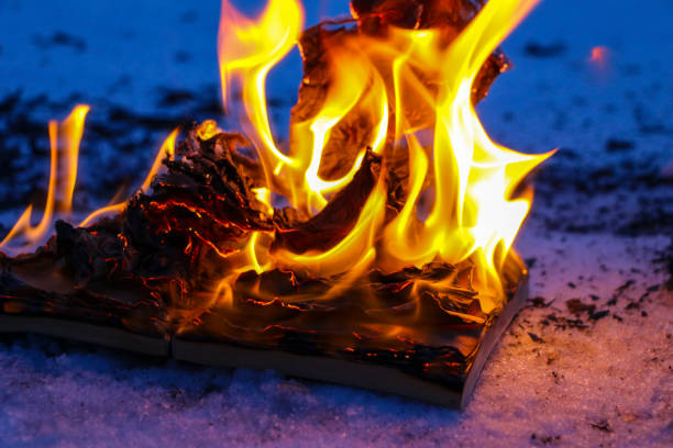 burning book in the snow. pages with the text in the open book burn with a bright flame.