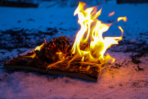 istock burning book in  snow. pages with the text in  open book burn with  bright flame. 1136306104