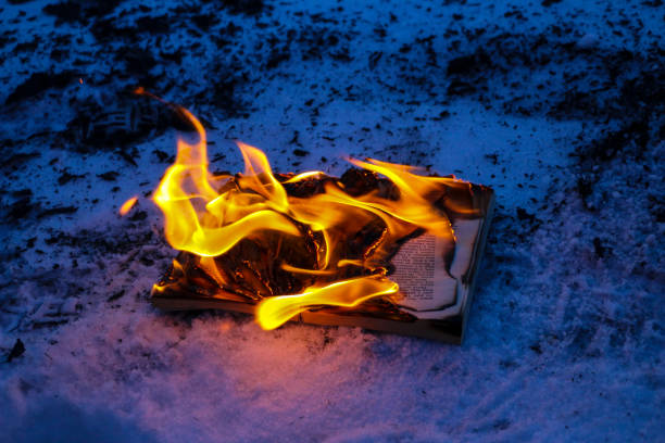 istock burning book in  snow. pages with the text in  open book burn with  bright flame. 1136306105