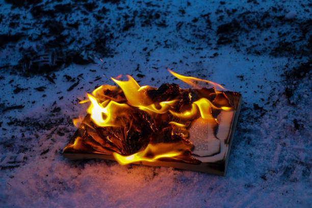 istock burning book in  snow. pages with the text in  open book burn with  bright flame. 1136306106