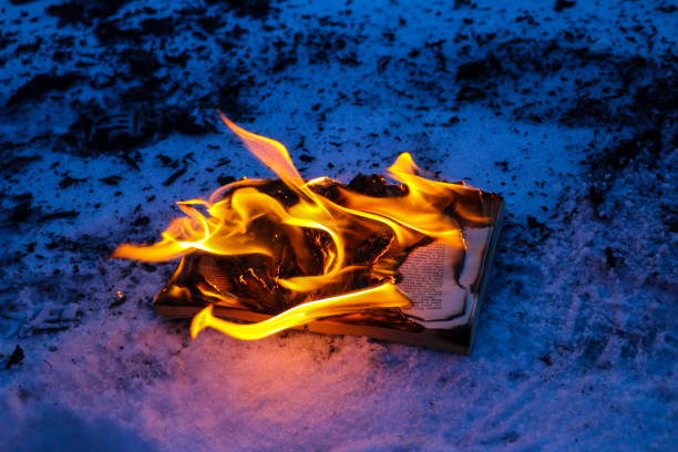 istock burning book in  snow. pages with the text in  open book burn with  bright flame. 1136306113