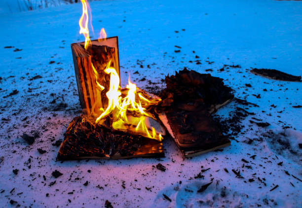 istock burning book in  snow. pages with the text in  open book burn with  bright flame. 1136306122