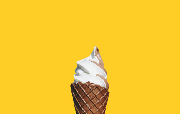 istock Soft cream ice cream with chocolate waffle cone, isolated on yellow background 1136310018