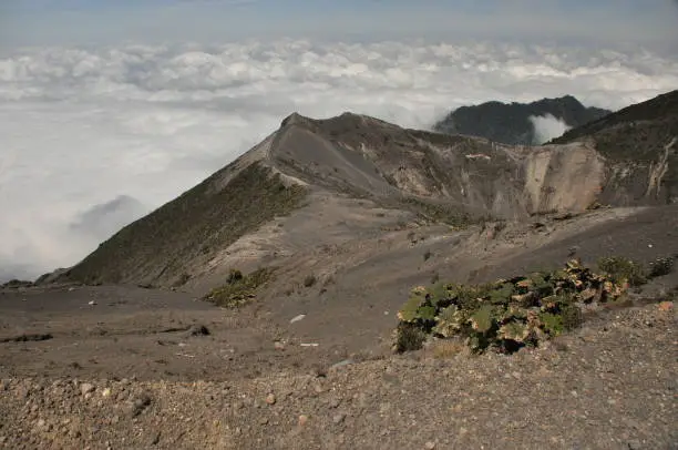 Photo of Irazu volcano in Costa Rica. Crater in clouds with protective barriers. Fragments of lava and pumice.