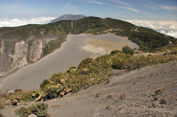 Irazu volcano in Costa Rica. Crater in clouds with protective barriers. Fragments of lava and pumice. Irazu volcano in Costa Rica. Crater in clouds with protective barriers. Fragments of lava and pumice. seismologist stock pictures, royalty-free photos & images