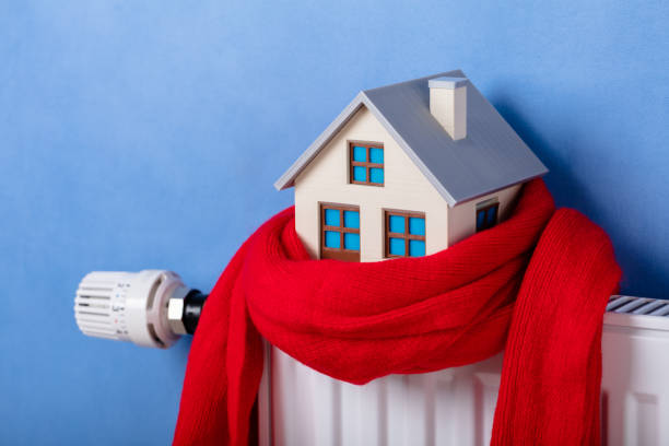 istock Heating Radiator With Model House And Knitted Scarf 1136317106