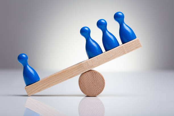 istock Pawns Figures On Wooden Seesaw 1136317171