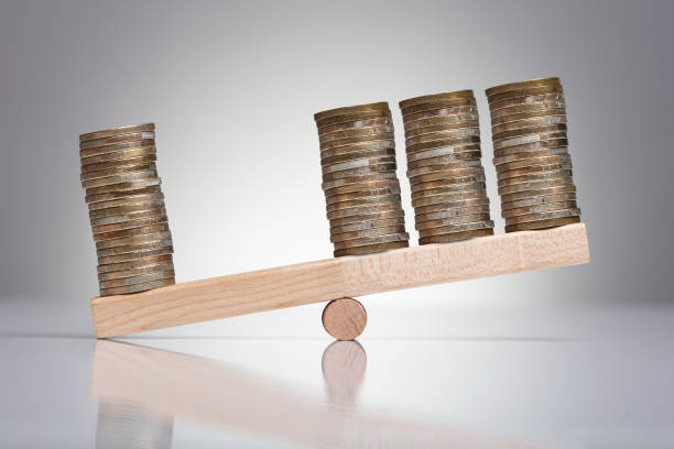 istock Stack Of Coins On Wooden Seesaw 1136317180