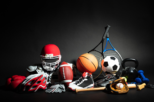 Variety Of Sport Balls And Equipment In Front Of Black Surface
