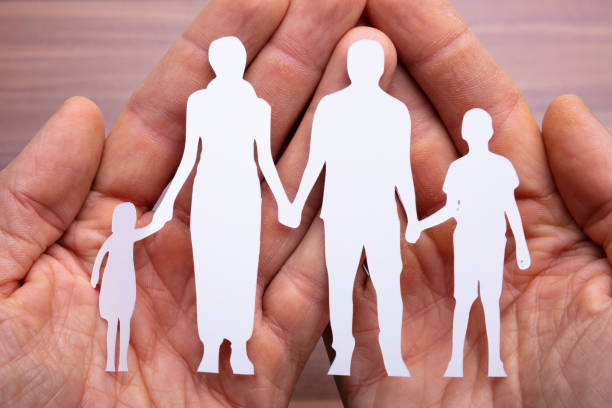istock Person's Hand Holding Family Cut Out 1136317398