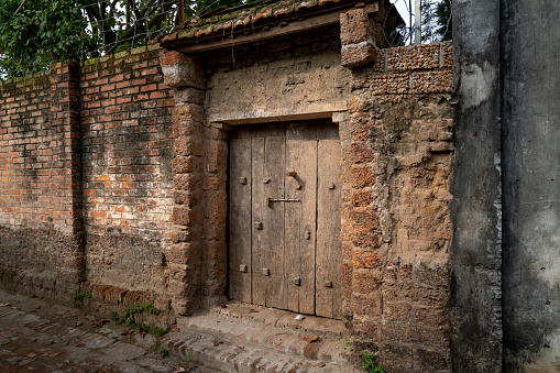 Old aged village entrance and wall made of laterite in Duong Lam ancient village, Son Tay district, Hanoi, Vietnam