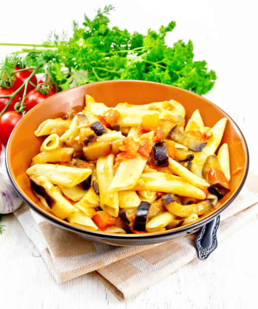 istock Pasta penne with eggplant and tomatoes on light board 1136325697