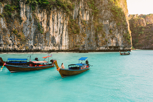 Scenic aerial view of young Caucasian  woman resting on long tail boat  near Koh Phi Phi, Thailand