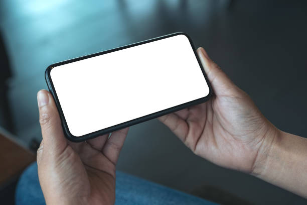 istock a woman's hand holding black mobile phone with blank desktop screen 1136327019