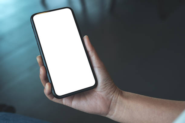 istock a woman's hand holding black mobile phone with blank desktop screen 1136327360