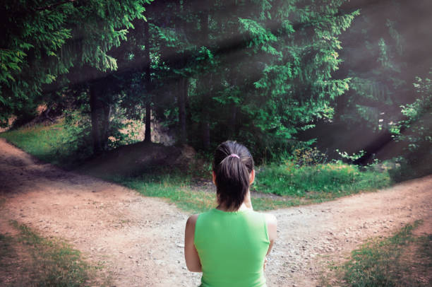 fille avec un choix près de la route fourchue - footpath field nature contemplation photos et images de collection