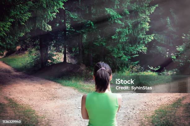 Girl With A Choice Near The Forked Road Stock Photo - Download Image Now - Footpath, Crossroad, Choice