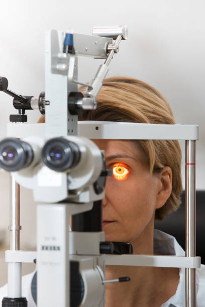 istock Mature Woman Looking Through Eye Test Equipment 1136331490