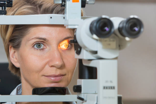istock Mature Woman Looking Through Eye Test Equipment 1136331496