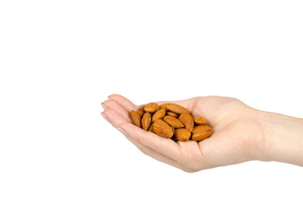 istock organic almond nuts with hand, healthy quick snack concept 1136335298