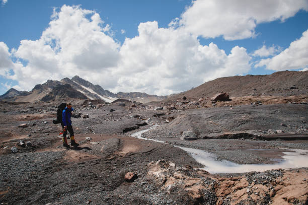 istock A mountaineer with a backpack walks in crampons walking along a dusty glacier with sidewalks in the hands between cracks in the mountain 1136335689