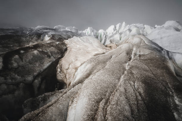 zbliżenie crack jest ciemnoniebieski pęknięcie znaleźć w pokrywie lodowej i czarne błoto na lodowcu. szeroki kąt i dramatyczne niebo - ice arctic crevasse glacier zdjęcia i obrazy z banku zdjęć