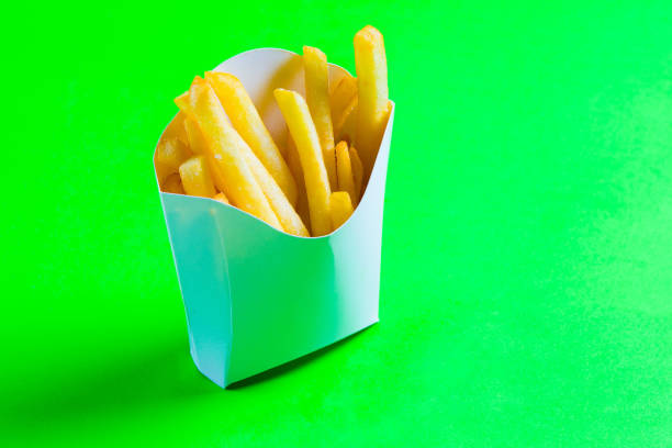 istock french fries straws in white box on green background 1136336909