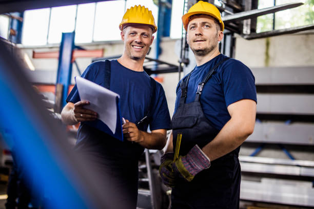 istock Happy manual workers working in industrial building. 1136339022