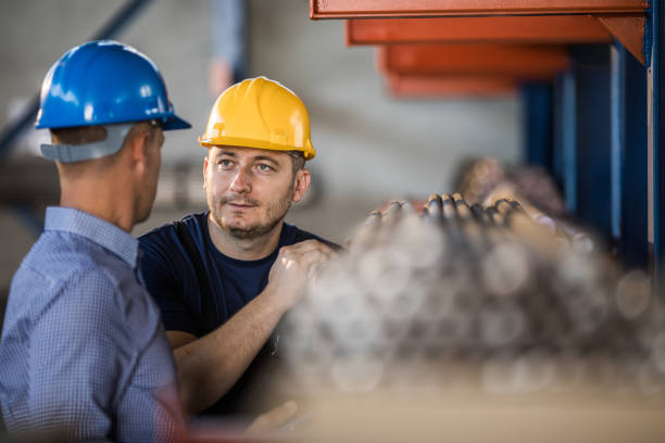 istock Manual worker talking to quality control inspector in aluminum mill. 1136339289