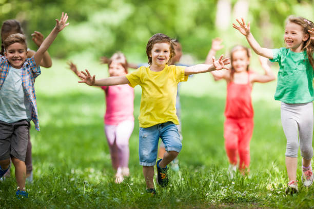istock Large group of happy kids having fun while running in springtime. 1136343480