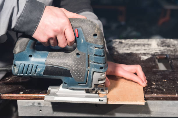 istock Close up of carpenter's hands working power tools for processing wood. Power Jigsaw 1136344177