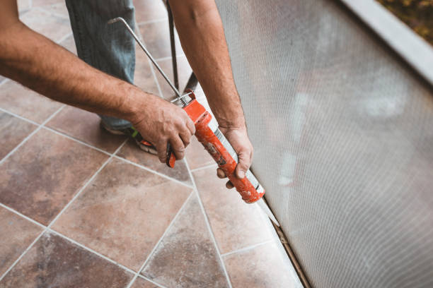 Construction Worker Using Silicone Glue View Of Worker who is Applying Silicone Sealant With Caulking Gun.  Man is Fixing Home Using Silicone Glue and Renovating the Home Apartment. sealant photos stock pictures, royalty-free photos & images
