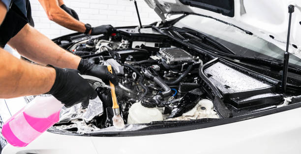 istock A man cleaning car engine with shampoo and brush. Car detailing or valeting concept. Selective focus. Car detailing. Cleaning with sponge. Worker cleaning. Car wash concept solution to clean 1136345596