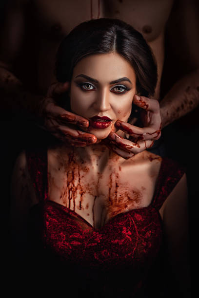 belle dame fière en robe rouge dans la tentation avant le diable, dame tenant son cou avec les mains, le sang circulant à travers les mains, artiste de maquillage professionnel, histoire sanglante de vampires - sensuality halloween witch devil photos et images de collection