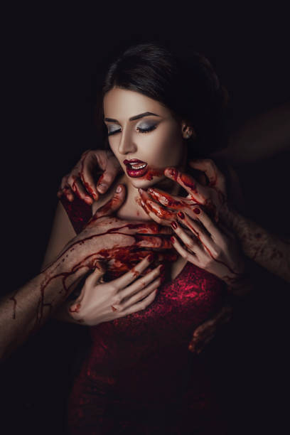 belle dame fière en robe rouge dans la tentation avant le diable, dame tenant son cou avec ses mains, le sang qui coule à travers les mains, maquilleuse professionnelle, histoire sanglante de vampires - sensuality halloween witch devil photos et images de collection