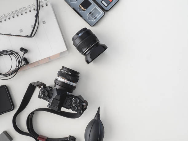 istock top view of work space photographer with digital camera, flash, cleaning kit, white table background. 1136346886