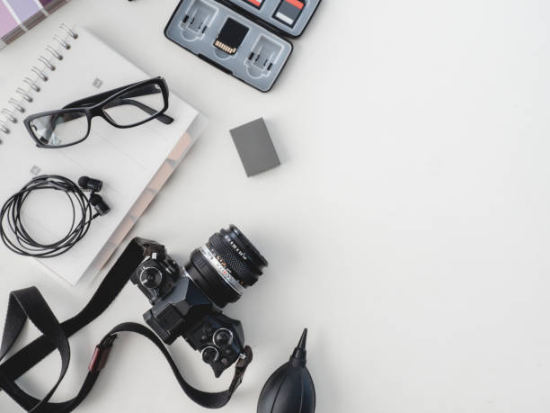 top view of work space photographer with digital camera, flash, cleaning kit, white table background.