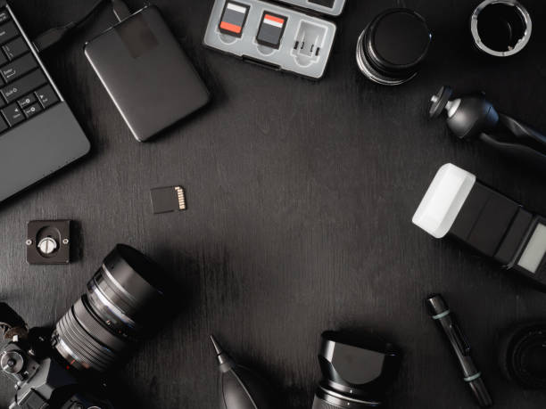 istock top view of work space photographer with digital camera, flash, cleaning kit, memory card, external harddisk, USB card reader, laptop and camera accessory on black table background 1136346911