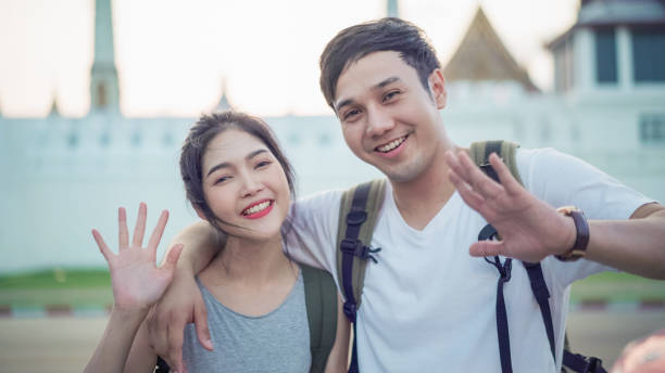 istock Asian couple traveler say hi to camera in Bangkok Thailand 1136347317