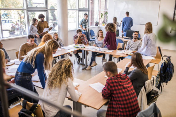 istock Large group of college students cooperating while learning in the classroom. 1136348101