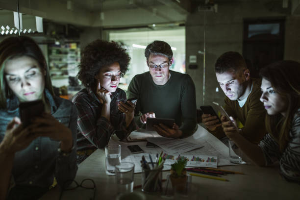 istock Team of freelancers using wireless technology in the dark office. 1136349145