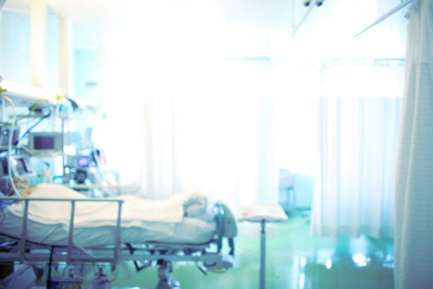 Bright hospital room with a patient in bed, unfocused background Bright hospital room with a patient in bed, unfocused background. intensive care unit photos stock pictures, royalty-free photos & images