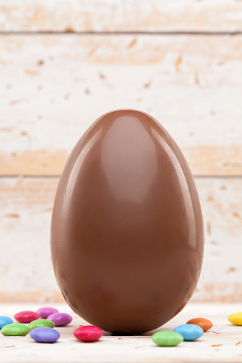 Delicious chocolate Easter holiday egg on rustic background
