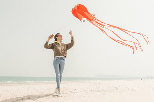 Woman enjoying sunny day and playing with a kite