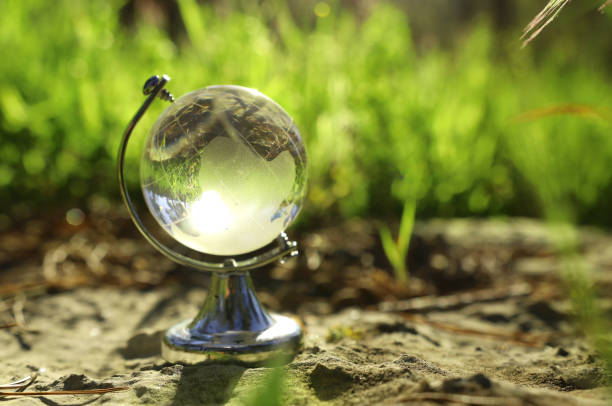 istock small crystal globe in front of sunset. travel and global issues concept 1136356705