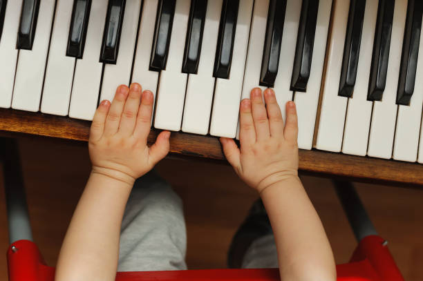 istock child hands on a white piano key 1136357212